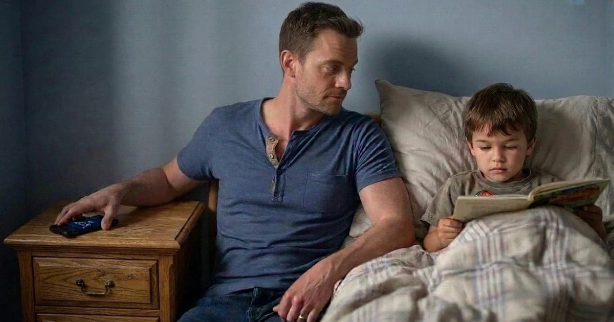 Father placing his smartphone into a bedside drawer while his young son reads a book under warm lamplight — illustrating healthy screen time boundaries for kids at bedtime